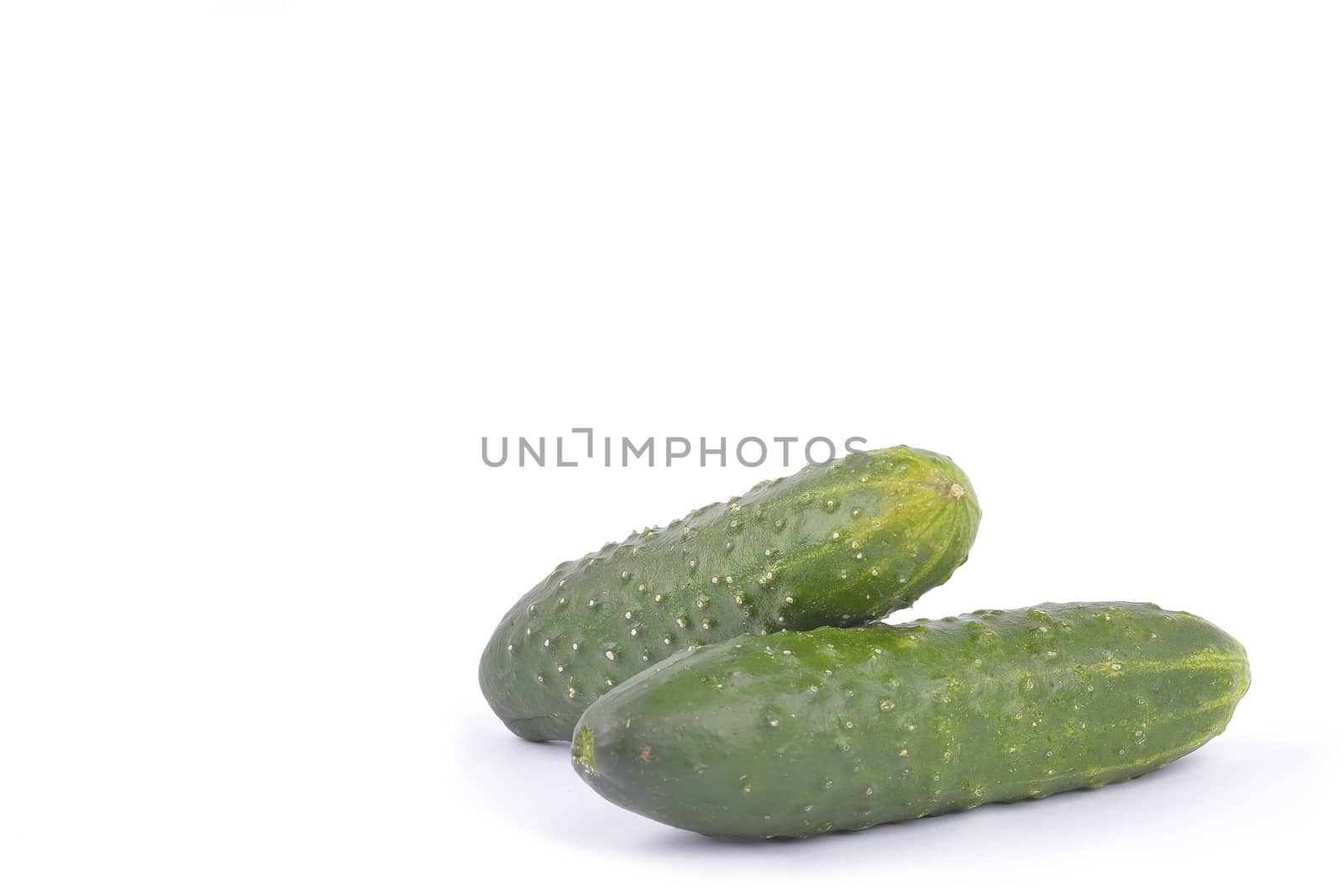 green cucumbers on white background by constantinhurghea