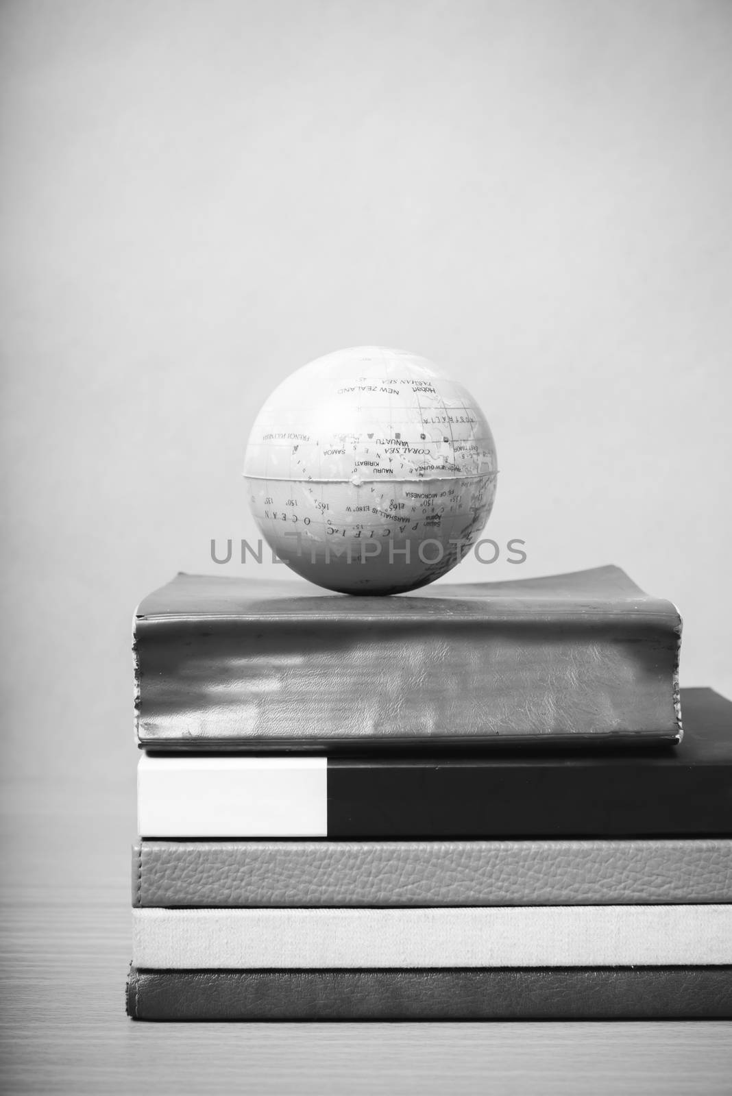 book and earth ball on wood background black and white color tone style