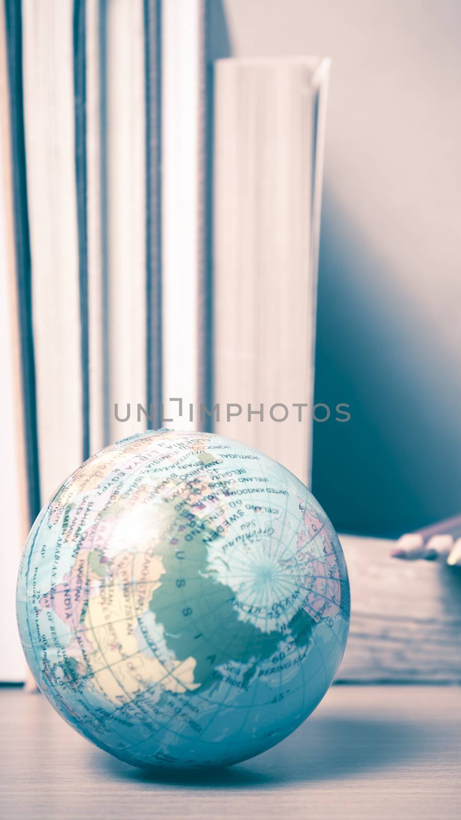 book and earth ball with color pencil on wood background vintage style