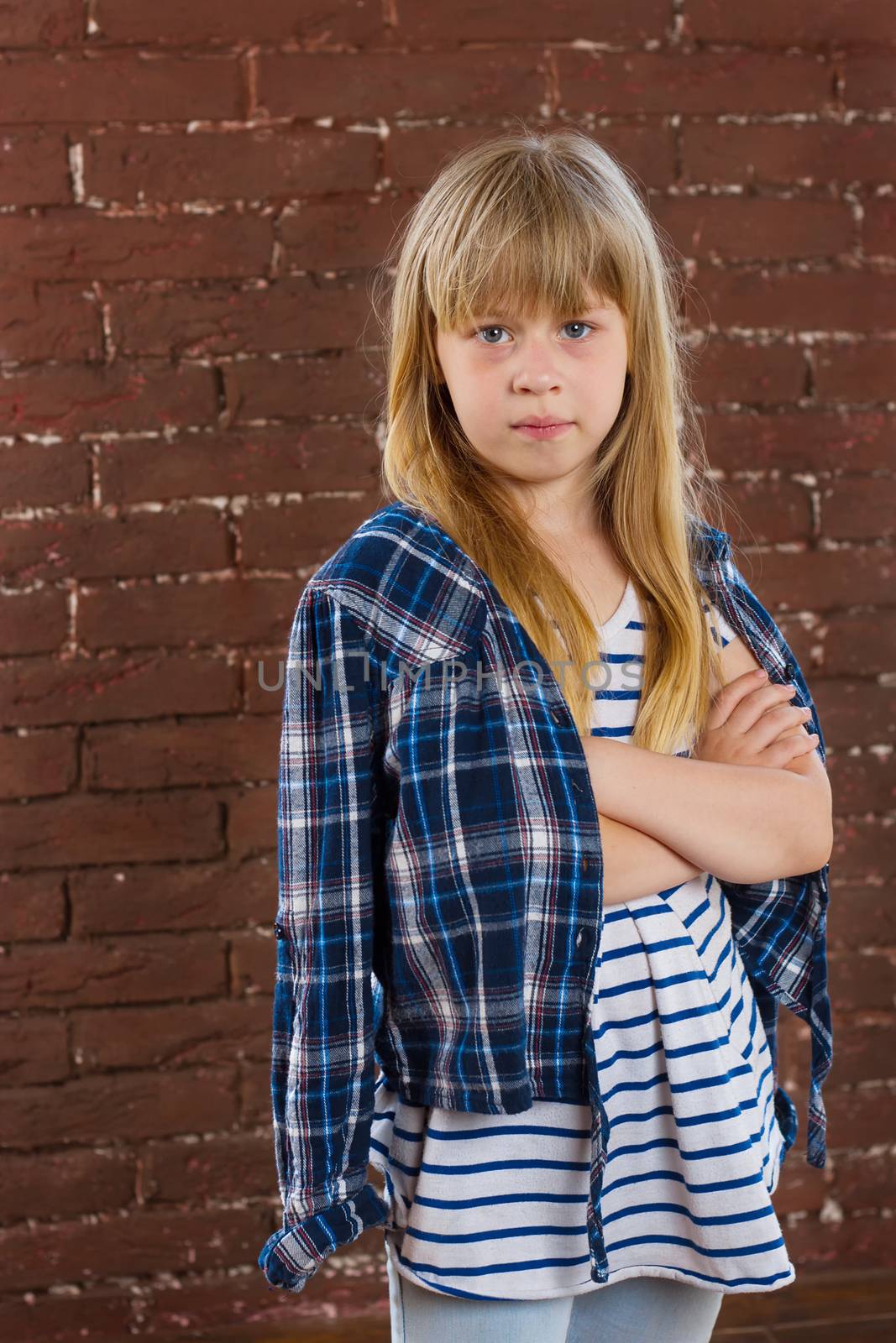 Girl 6 years old in jeans and shirt is thrown against the wall. half-length