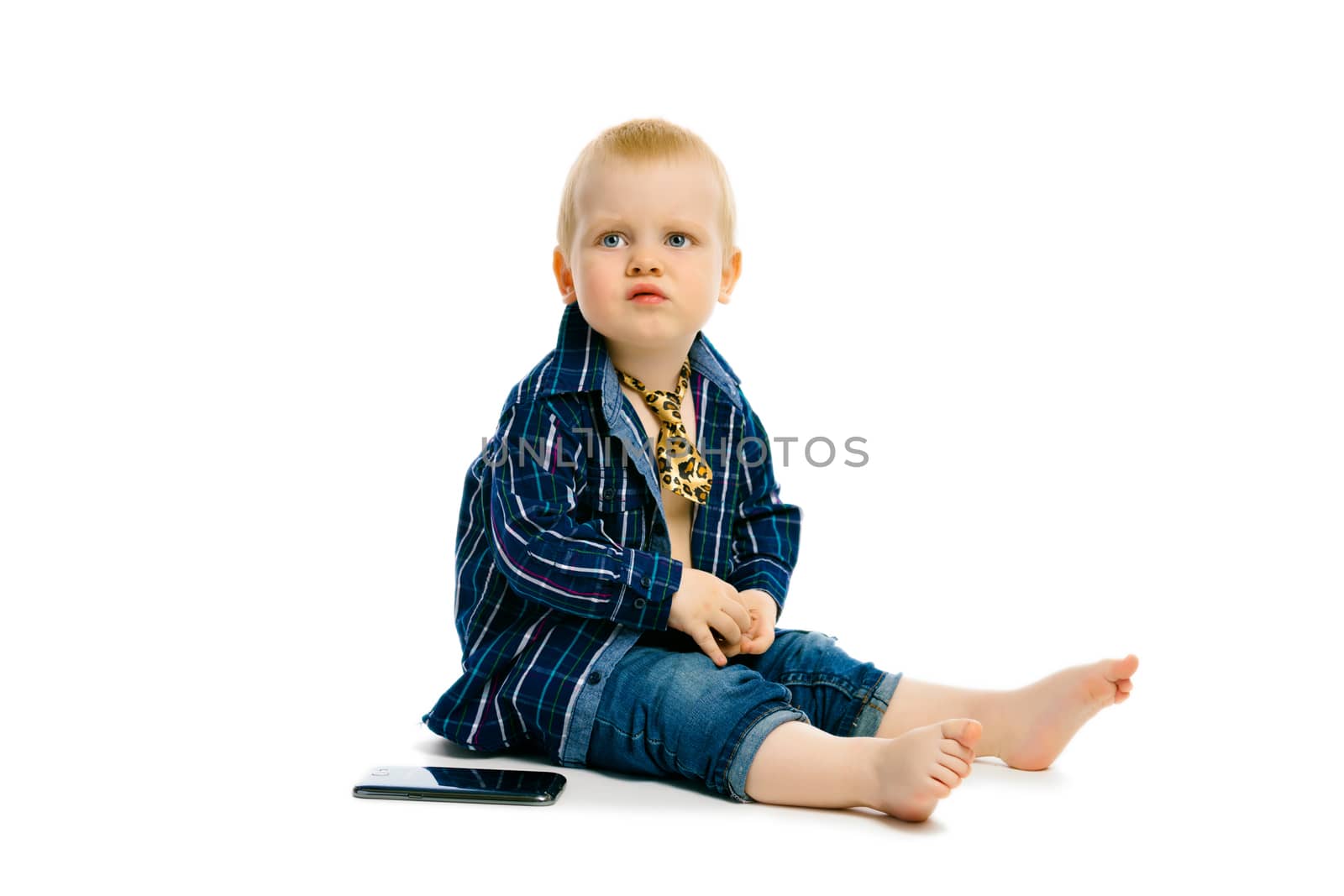 baby boy in a tie sitting on a white floor