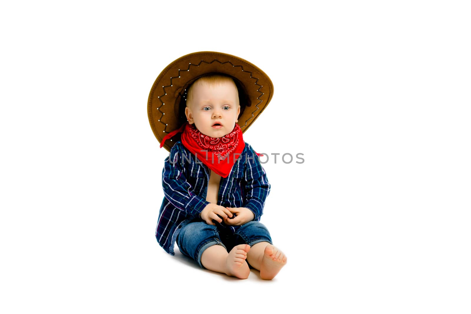 baby boy in a cowboy hat sitting on a white floor