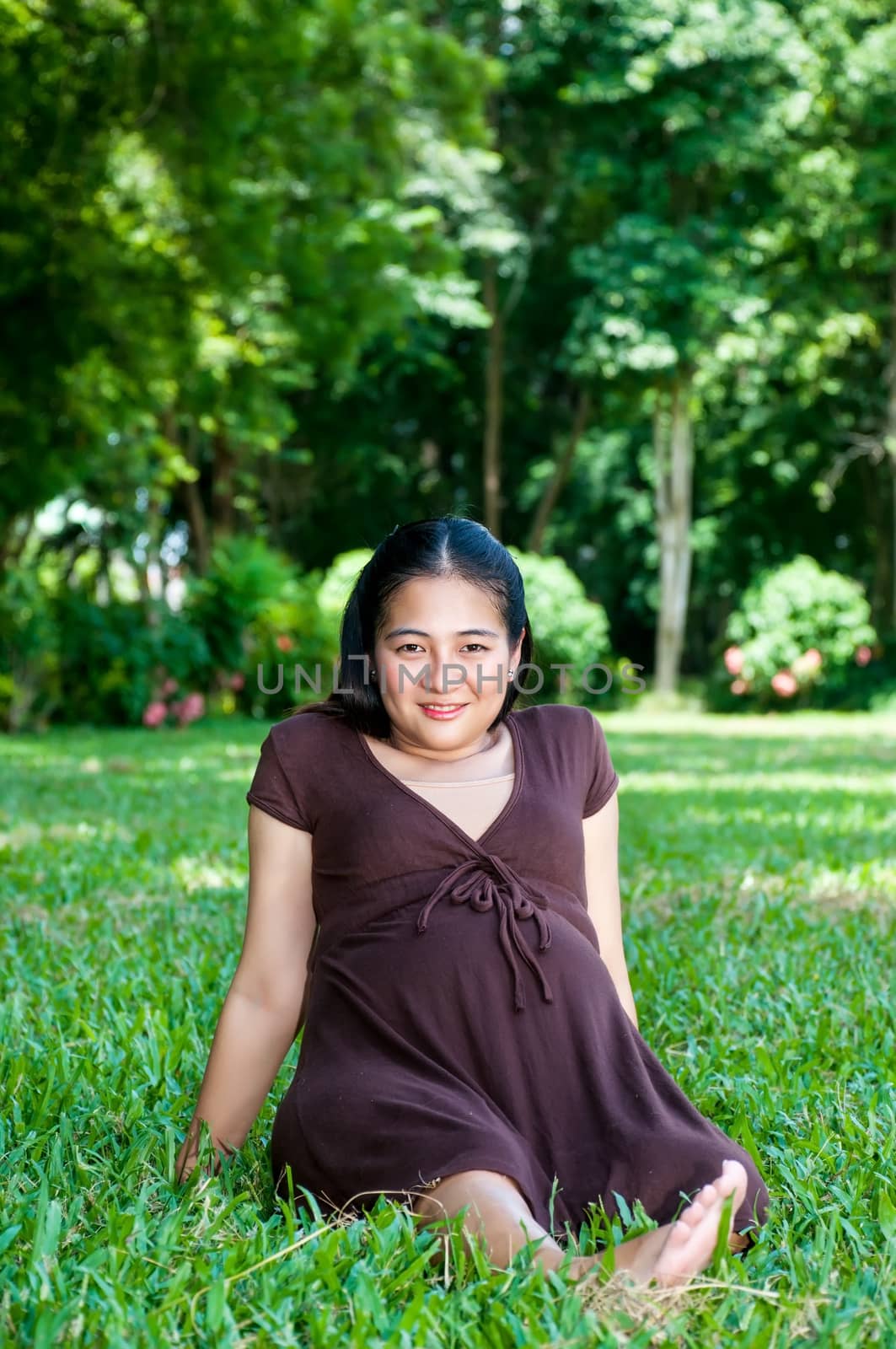 Pregnant woman sitting in the park . in anticipation of the chil by Yuri2012