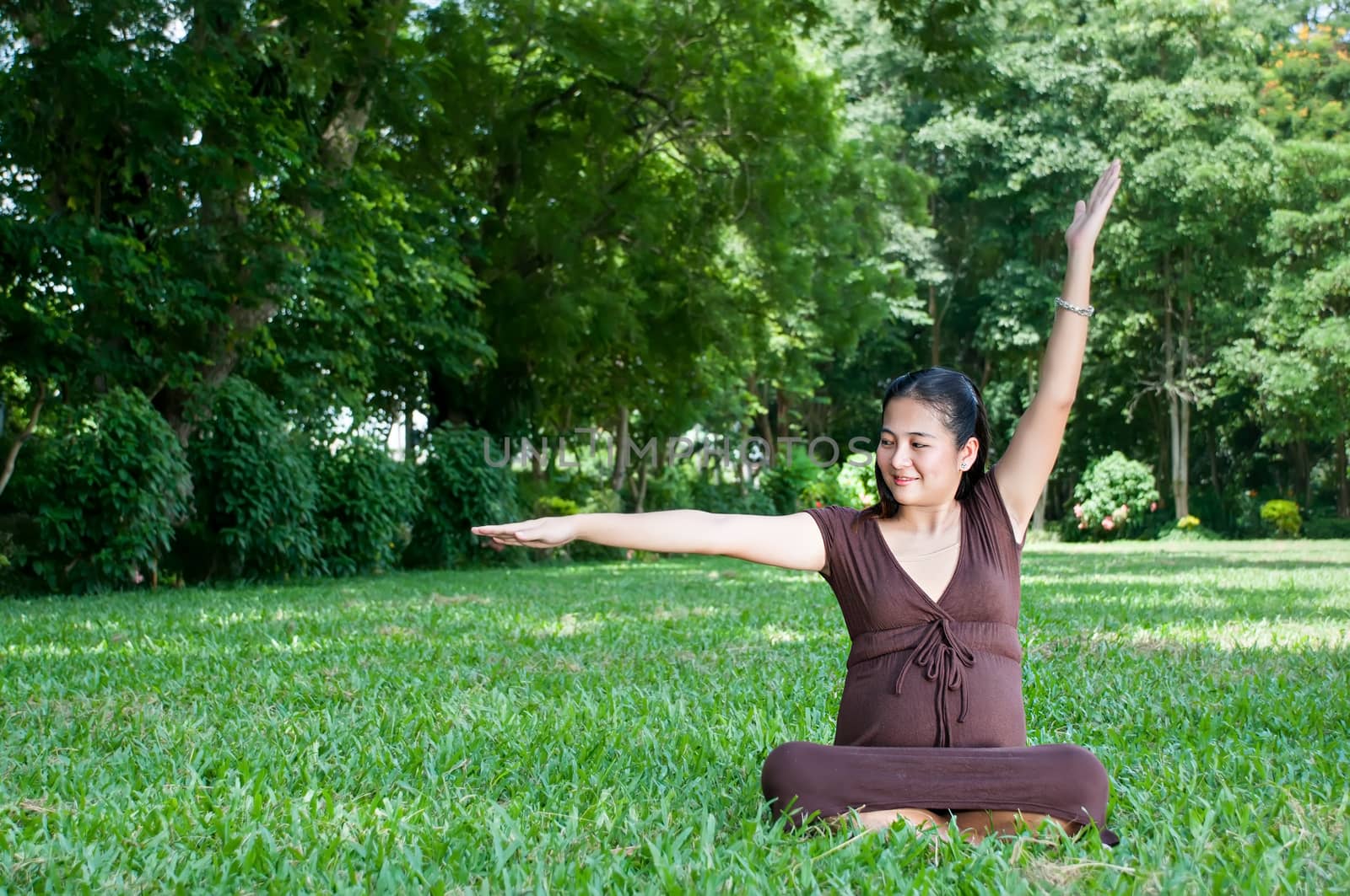 Pregnant woman sitting in the park . in anticipation of the chil by Yuri2012