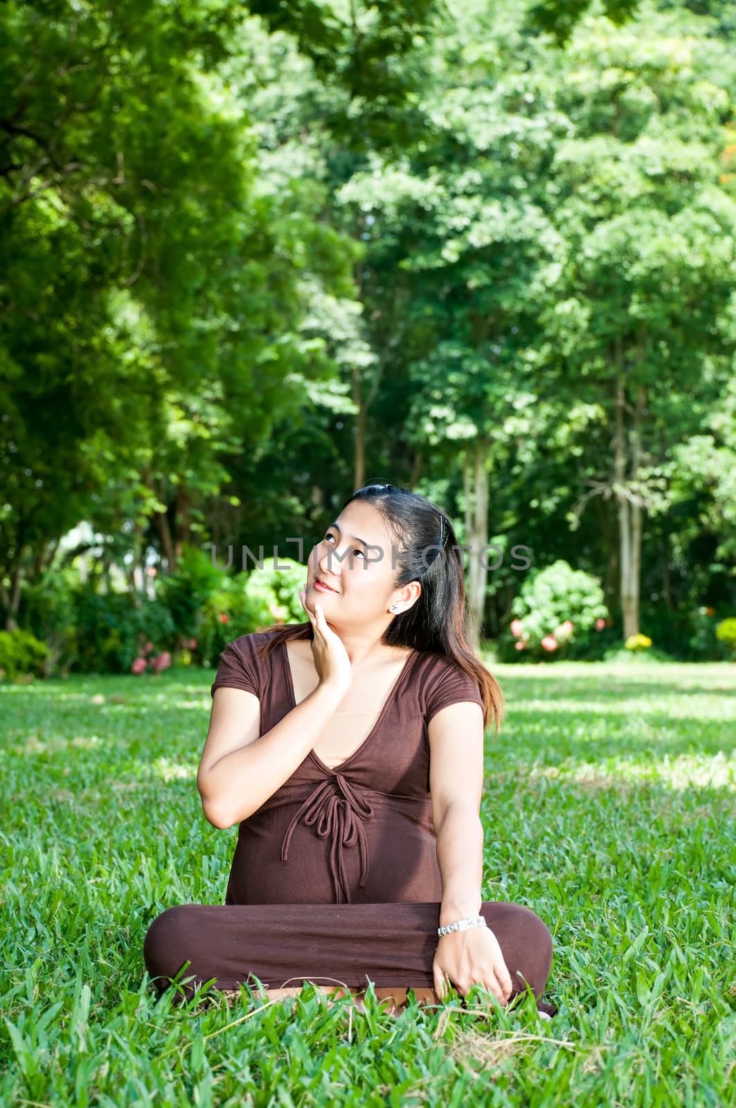 Pregnant woman sitting in the park . in anticipation of the chil by Yuri2012