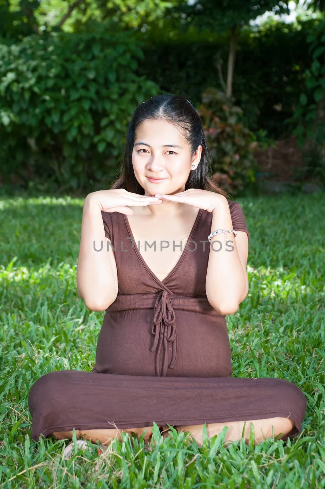 Pregnant woman sitting in the park . in anticipation of the chil by Yuri2012