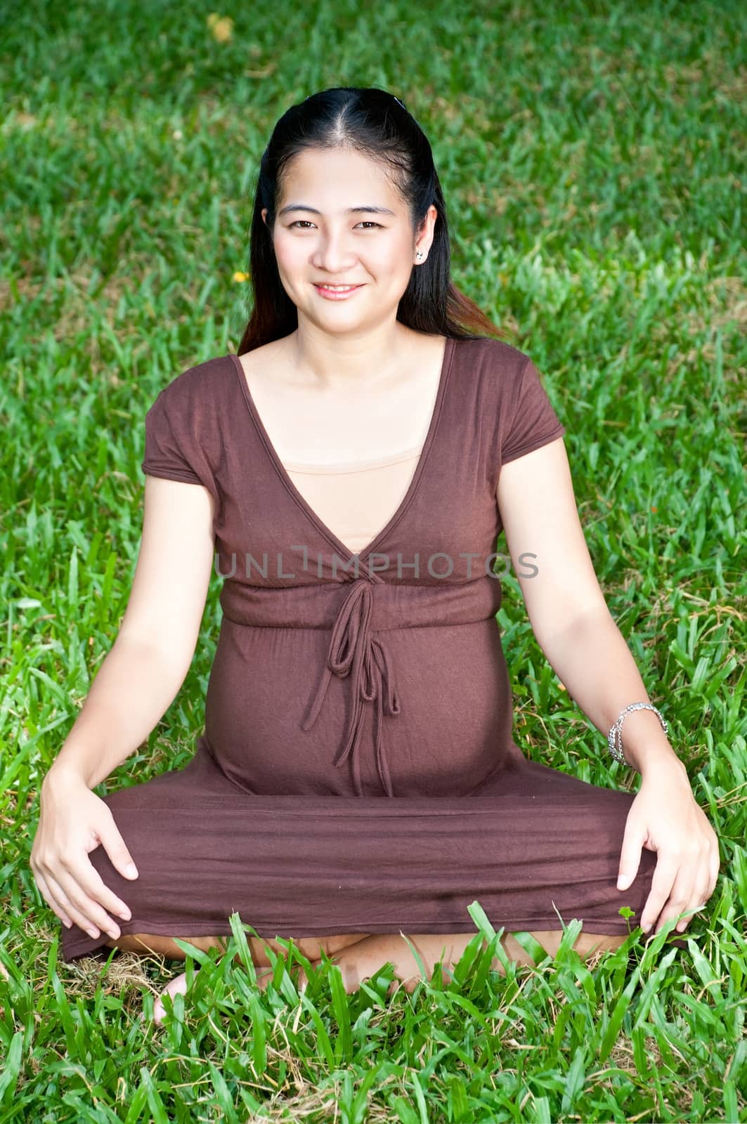 Pregnant woman sitting in the park . in anticipation of the chil by Yuri2012