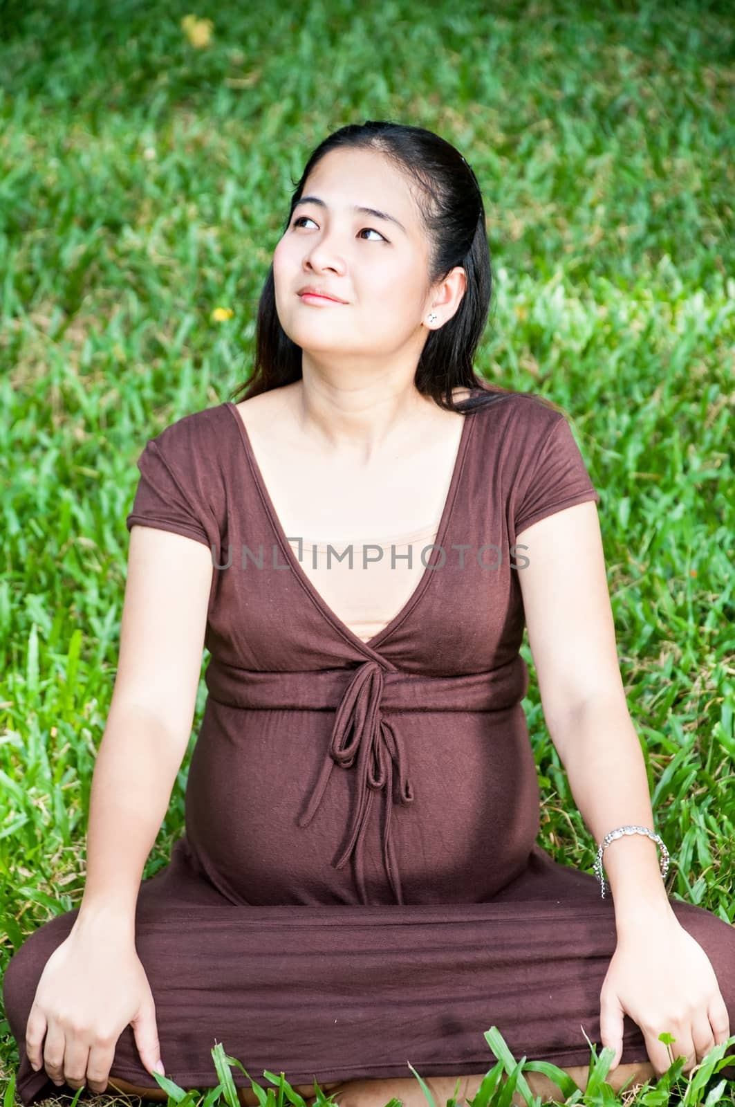 Pregnant woman sitting in the park . in anticipation of the chil by Yuri2012