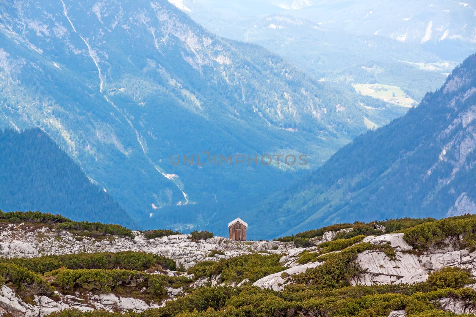 Small cottage at the abyss, mountain panorama in the background