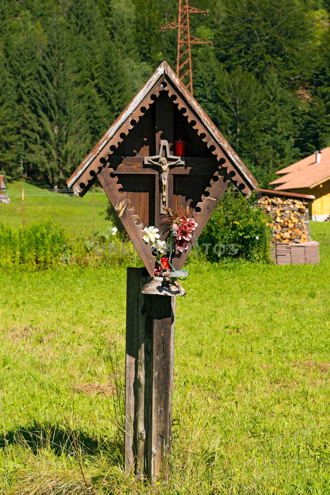 Typical wooden wayside shrine with jesus on cross in Italian alps. Trentino Alto Adige, Italy