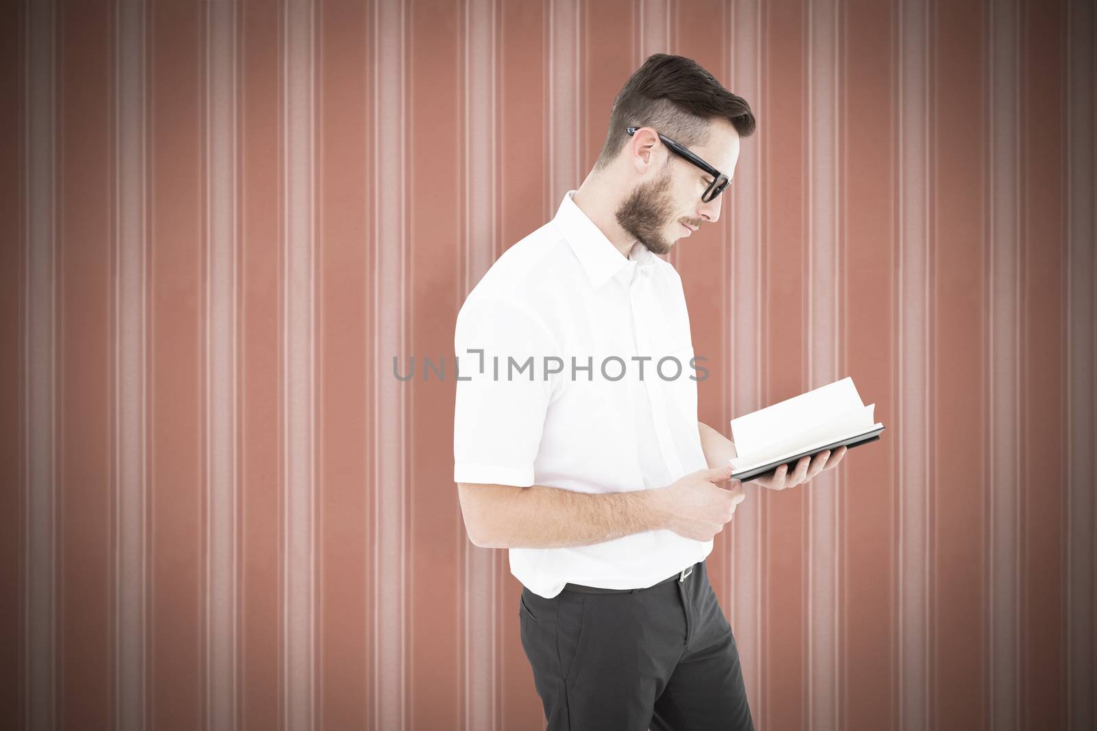 Composite image of geeky young man reading from black book by Wavebreakmedia