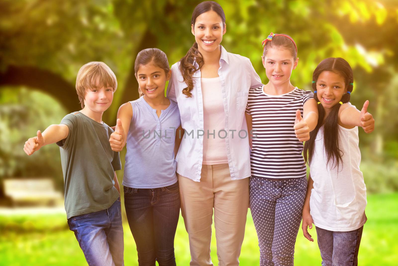 Cute pupils and teacher smiling at camera in computer class  against trees and meadow in the park