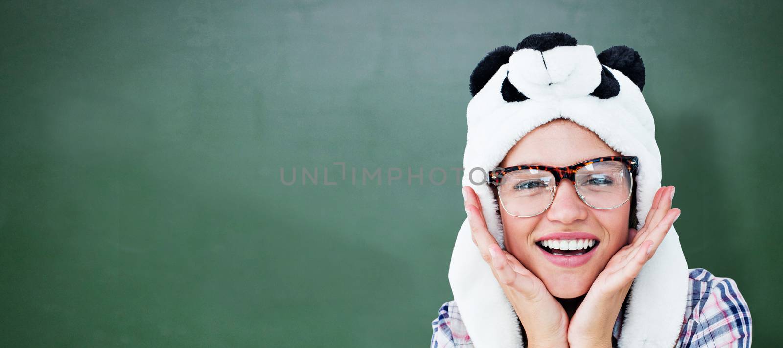 Geeky hipster smiling at camera  against green chalkboard