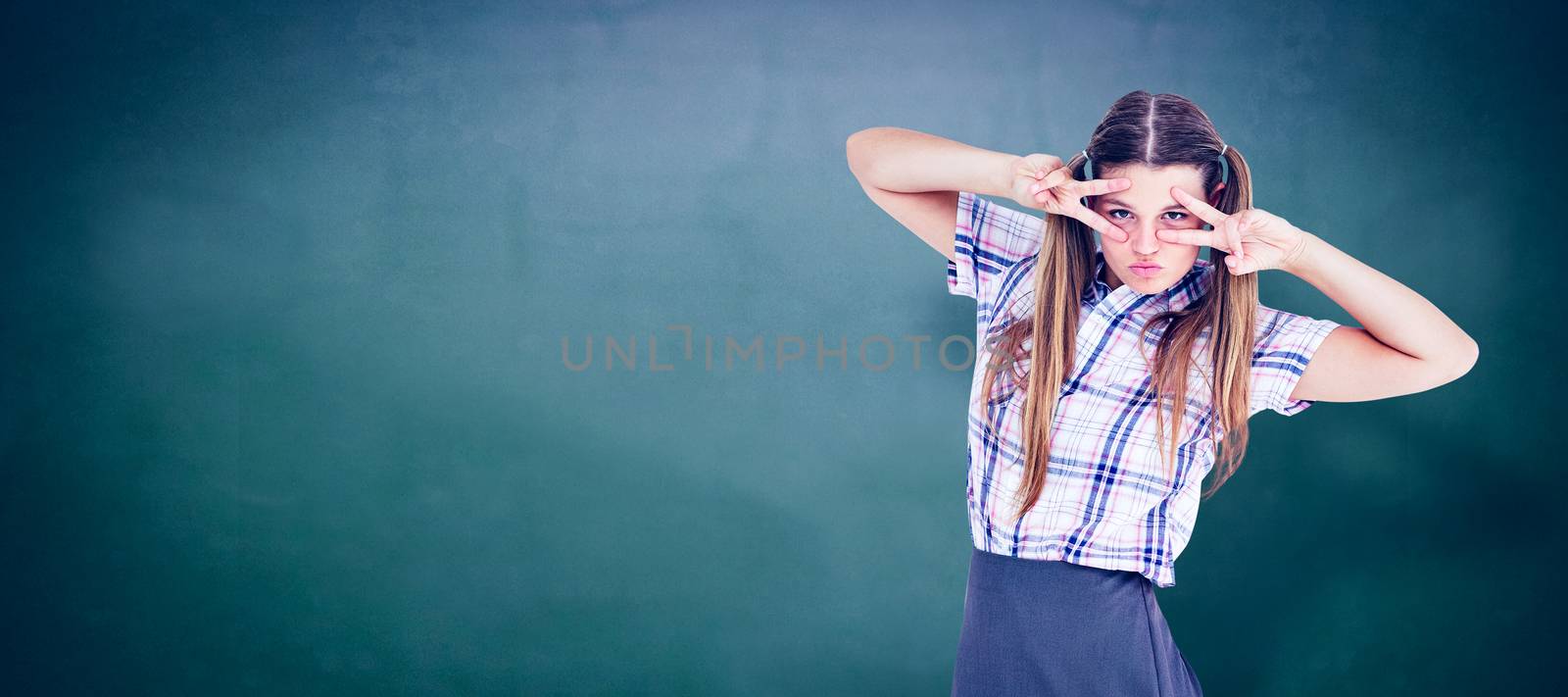 Geeky hipster dancing  against green chalkboard