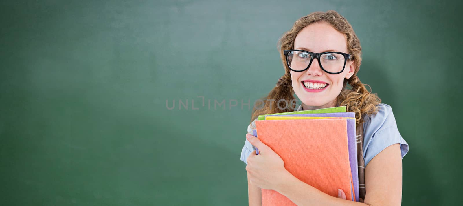 Geeky hipster woman holding files  against green chalkboard