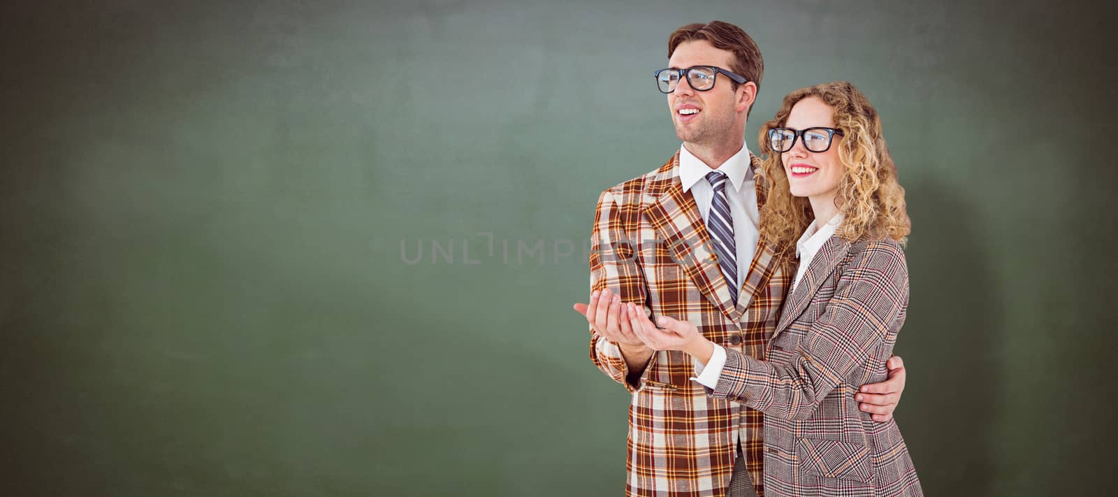 Geeky young hipster smiling at camera against green chalkboard
