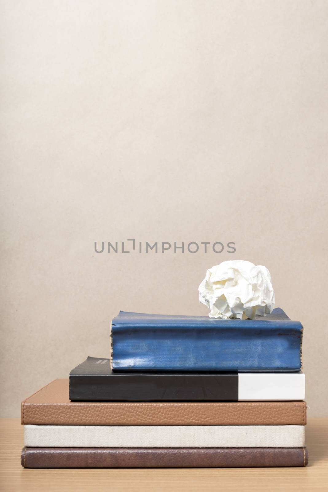 book and crumpled paper on wood background