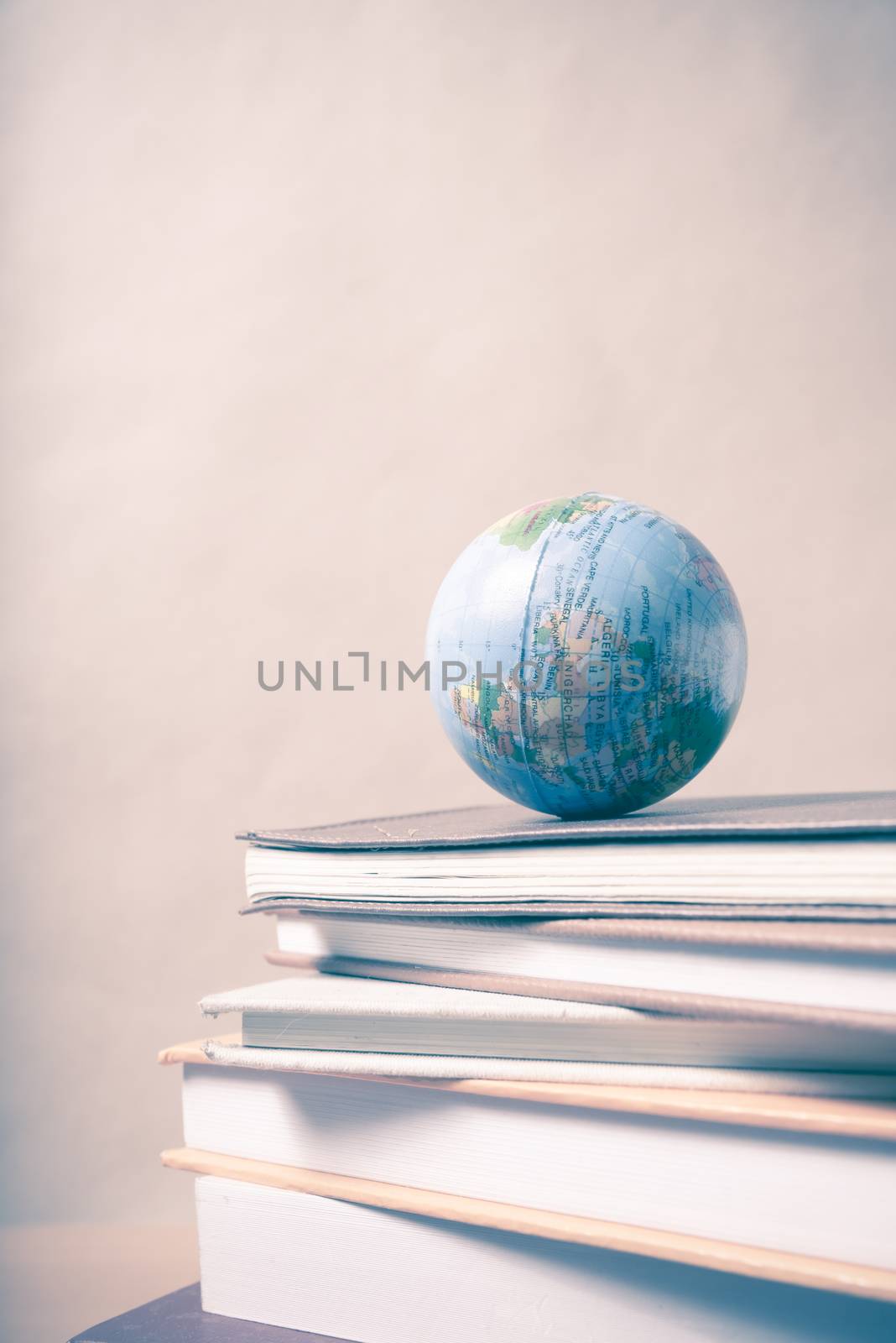 stack of book and earth ball on wood background vintage style