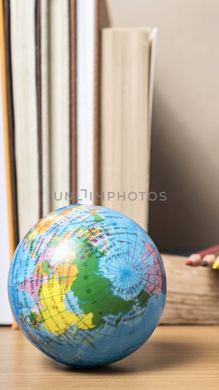 book and earth ball with color pencil on wood background