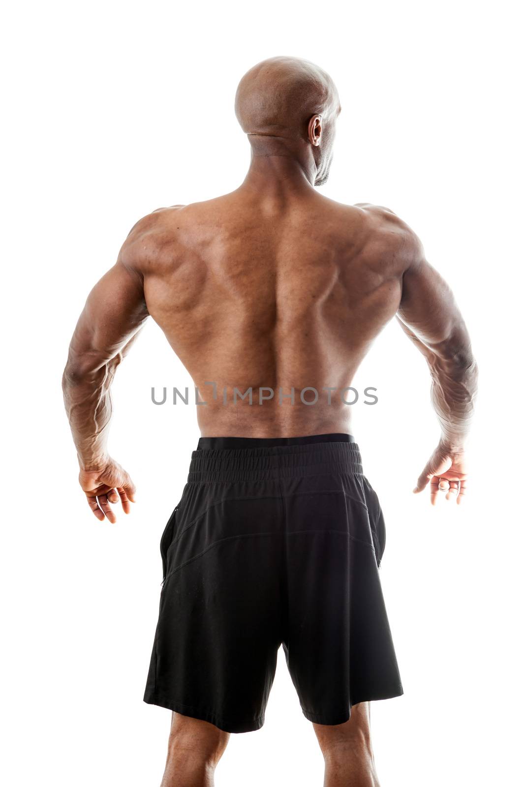Toned and ripped lean muscle fitness man standing in front of a white background.