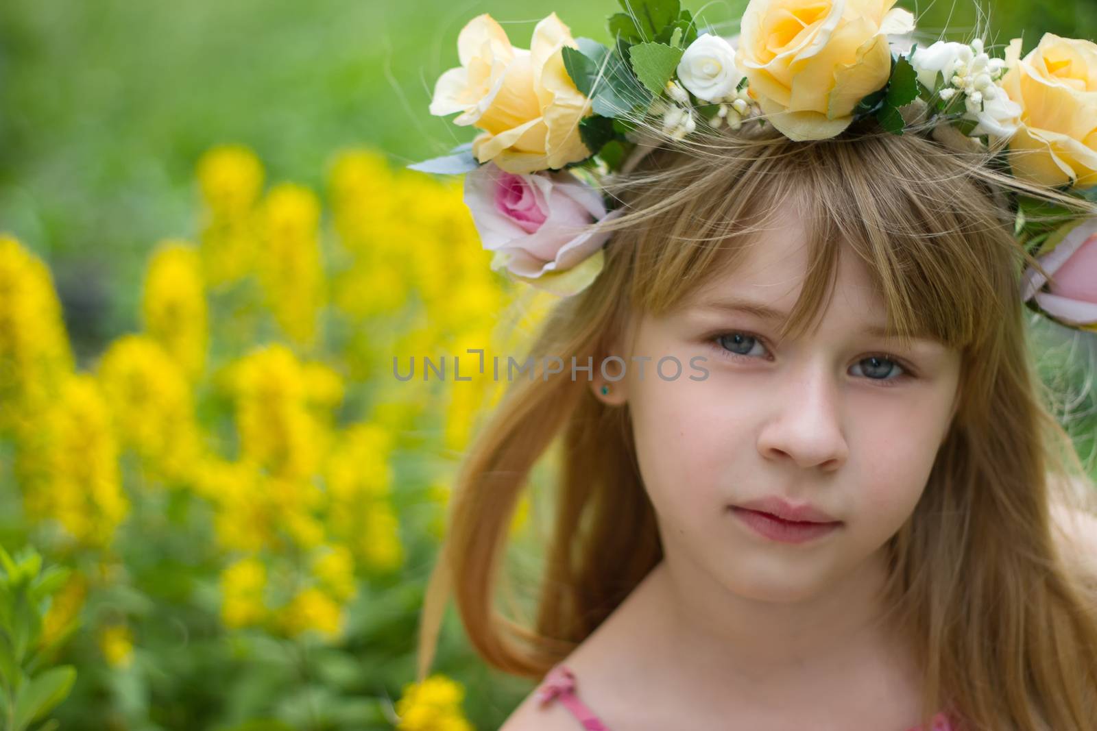 Girl 6 years old in a wreath close-up against a landscape