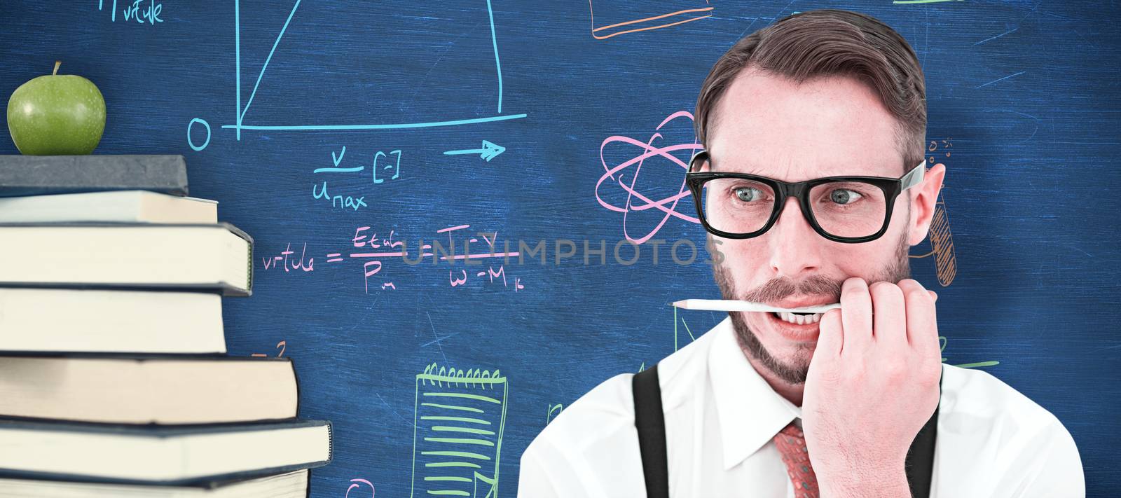 Geeky hipster biting on pencil against blue chalkboard