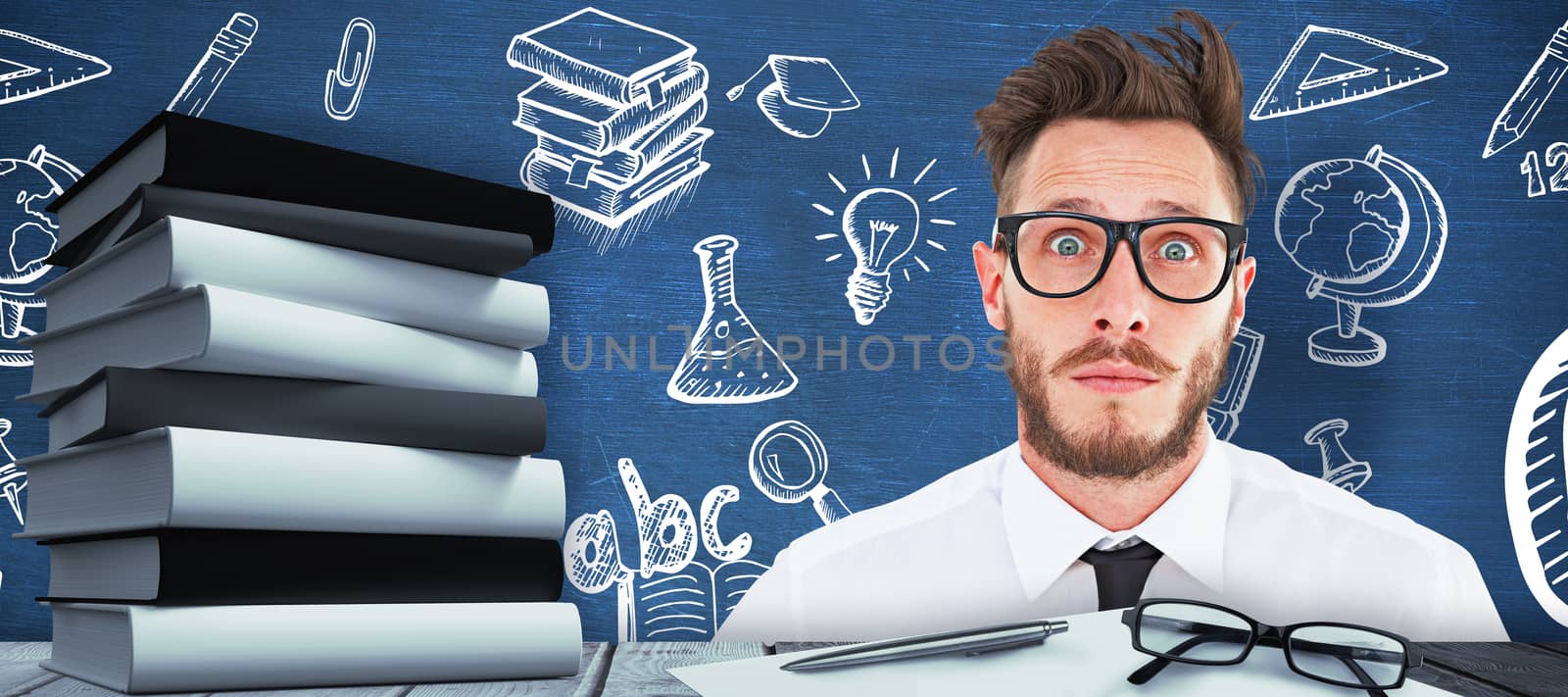 Geeky young businessman looking at camera against blue chalkboard