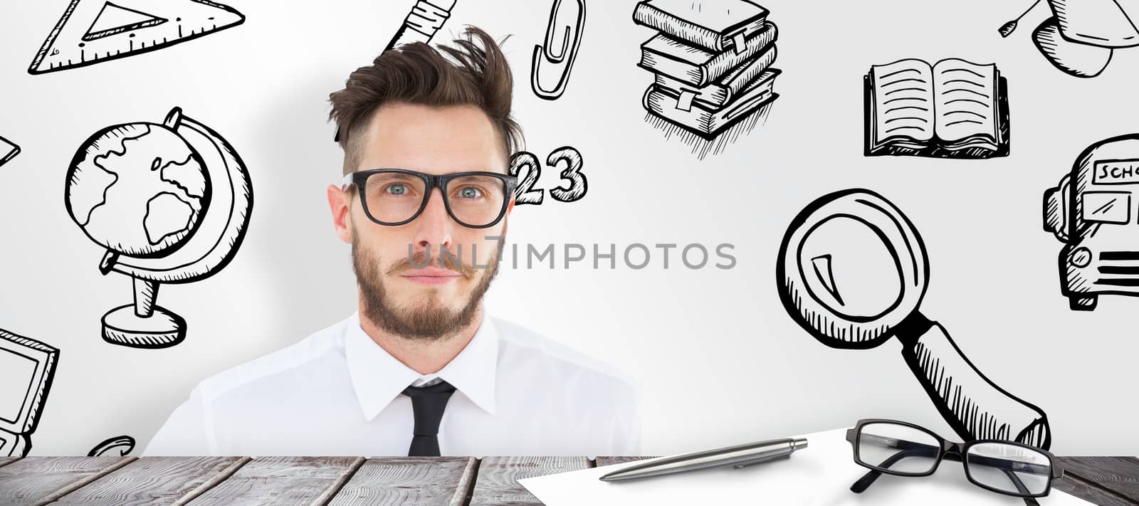 Geeky young businessman looking at camera against desk