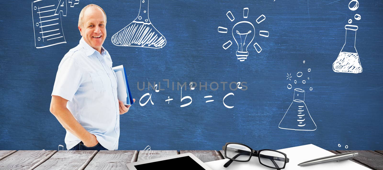 Mature student holding files against blue chalkboard