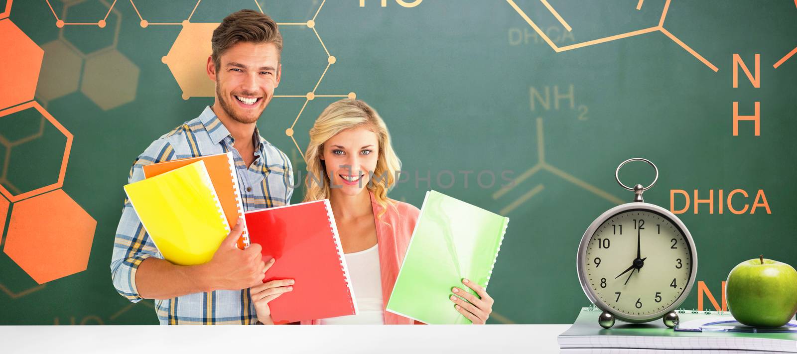 Happy students smiling at camera  against green chalkboard