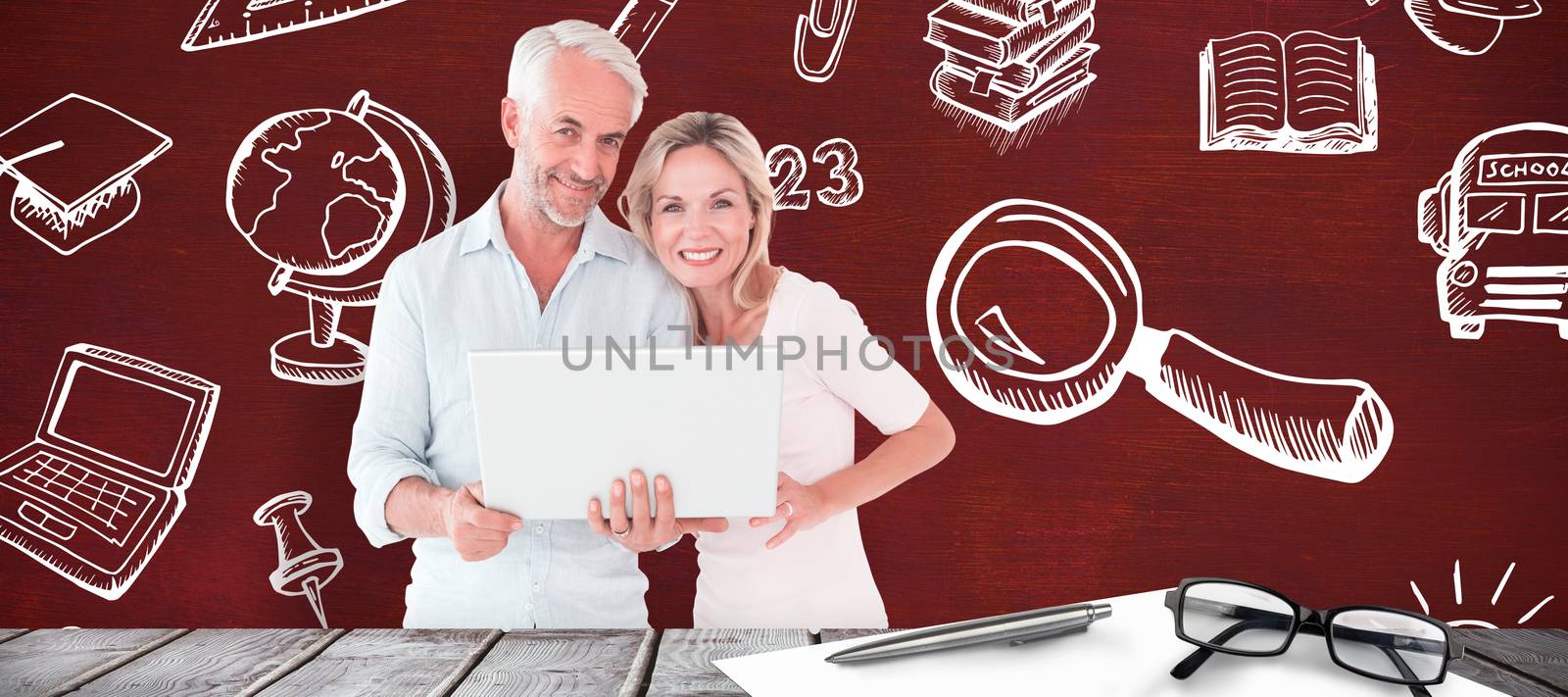 Mature students using laptop against desk
