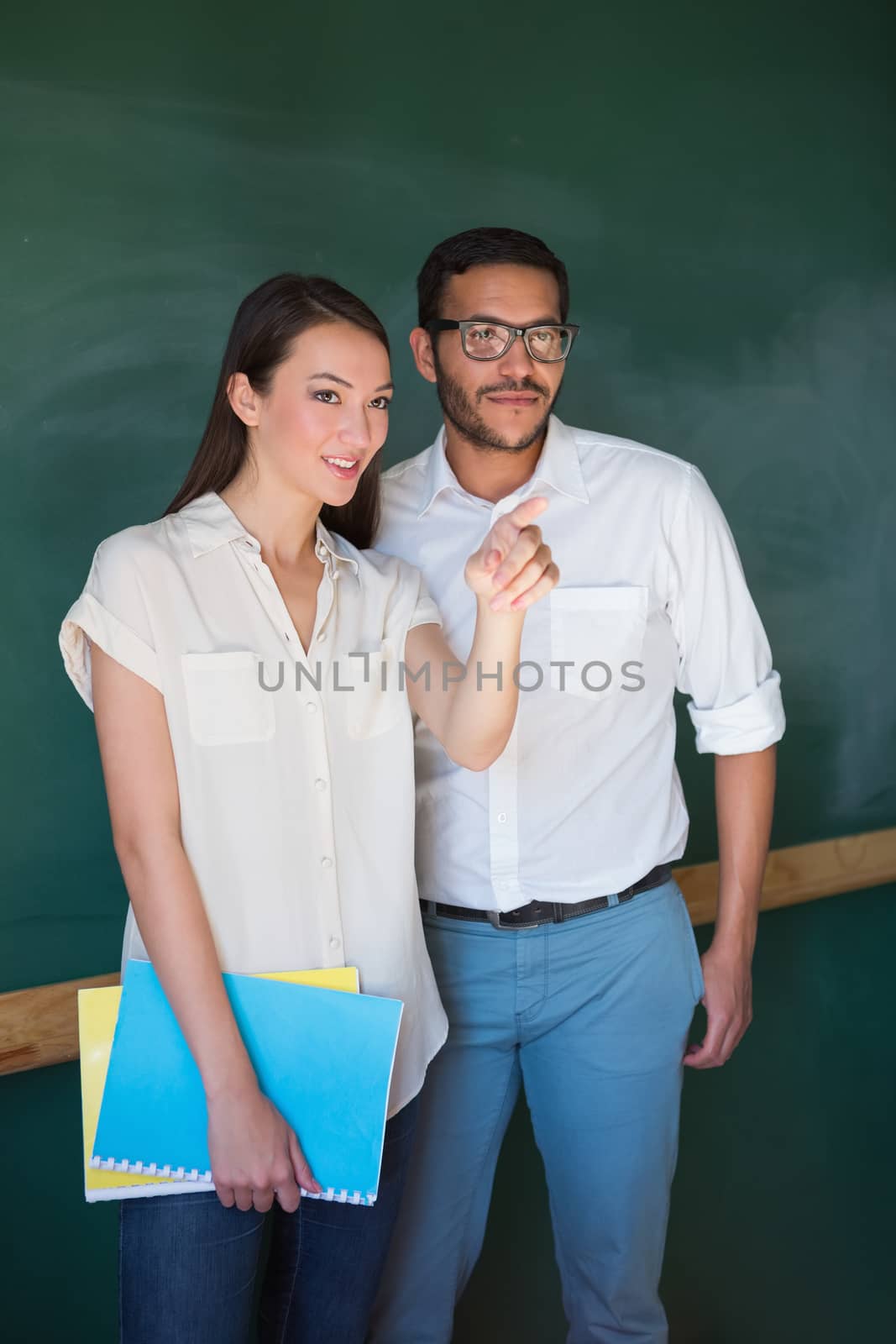 Young businesswoman showing something to male colleague in office