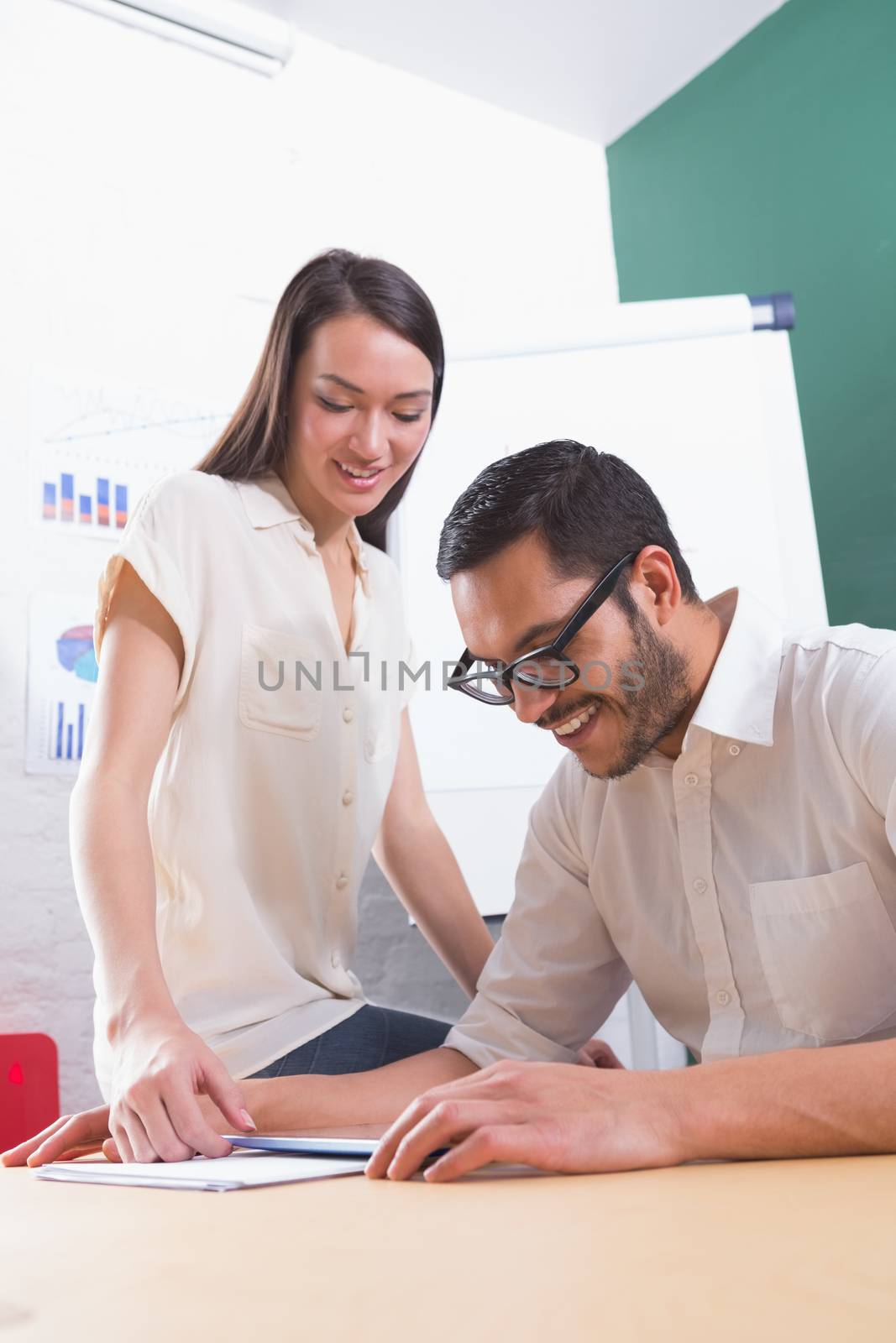 Two casual business people using digital tablet