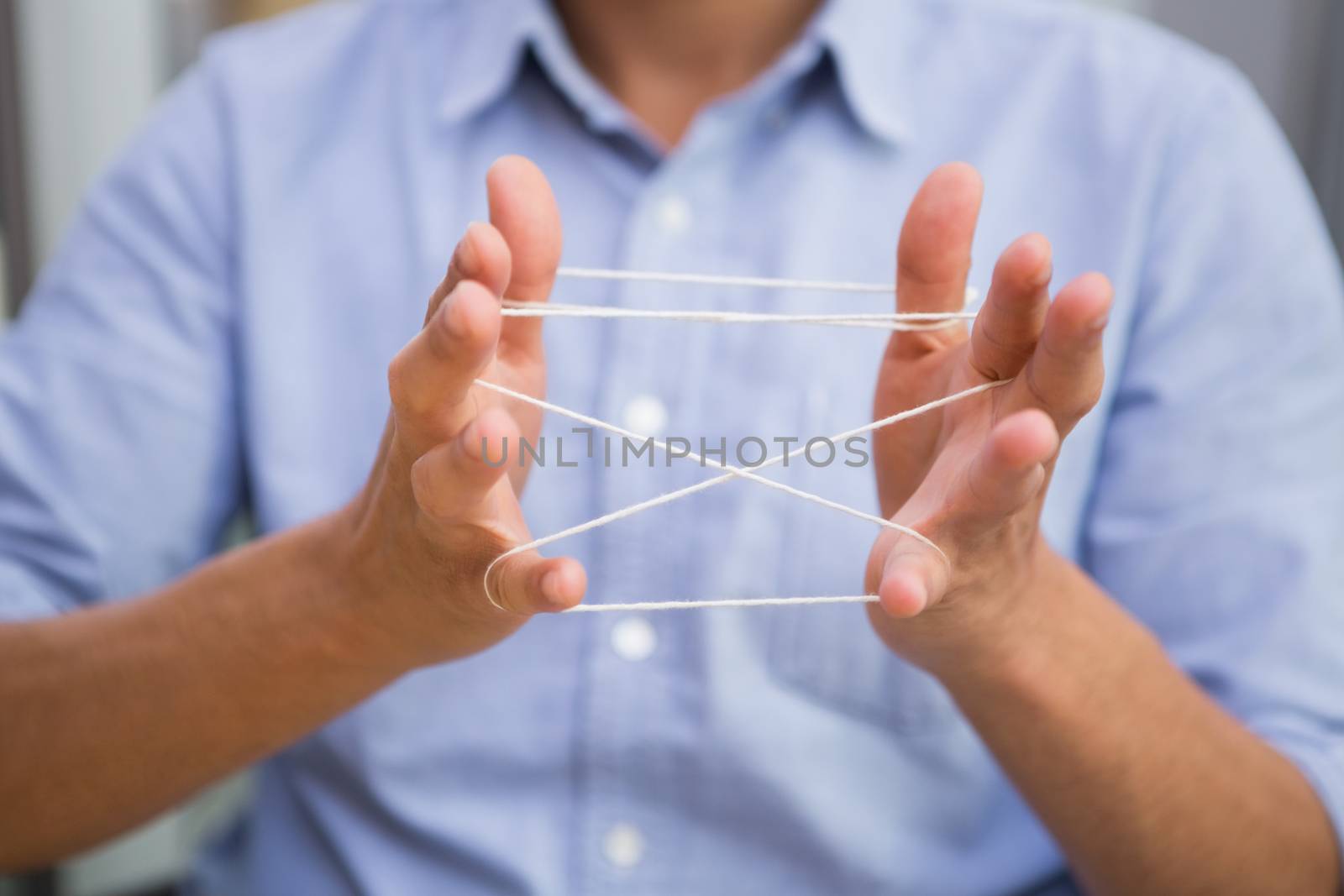 Close up mid section of man holding tangled string