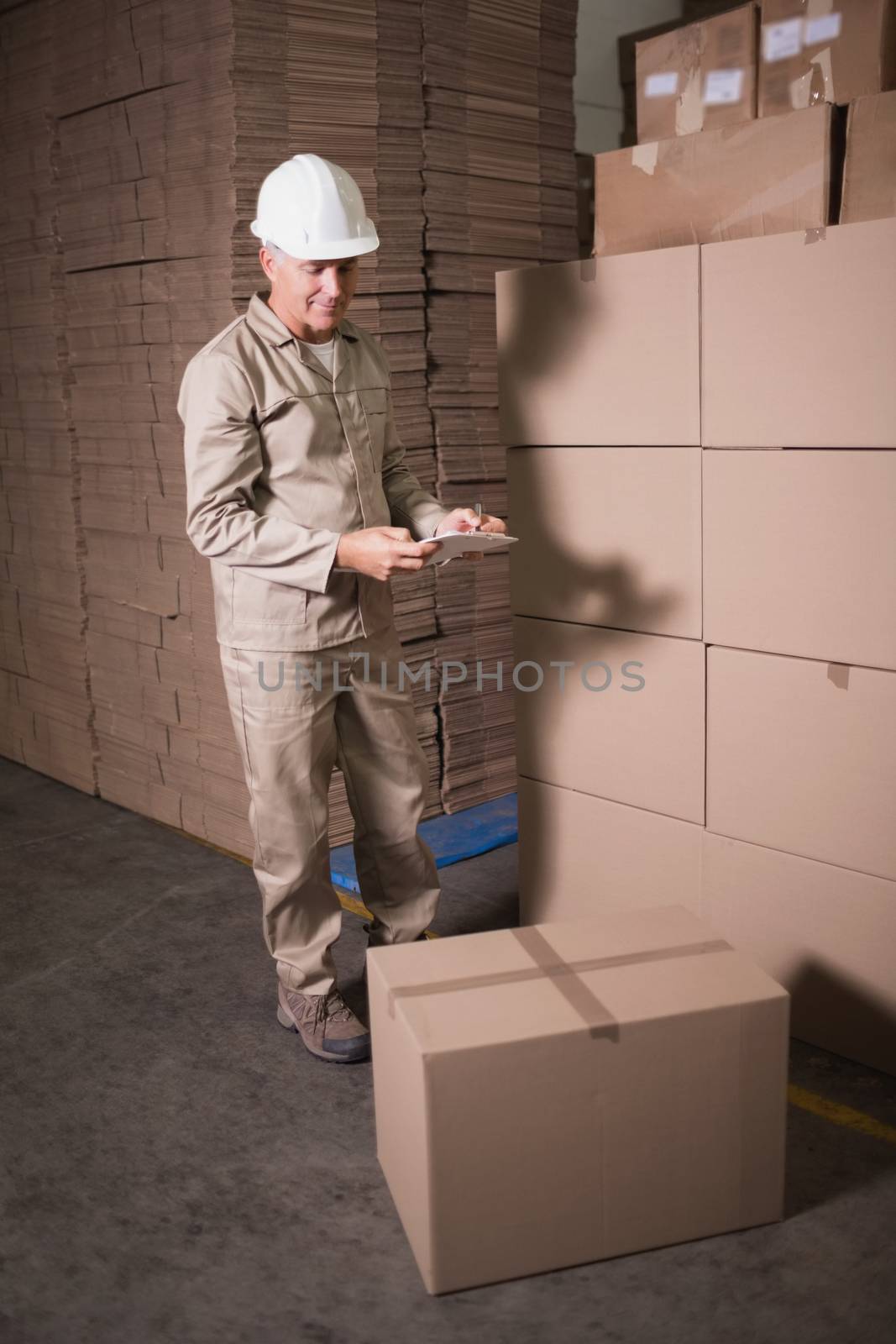 Warehouse worker with clipboard in warehouse