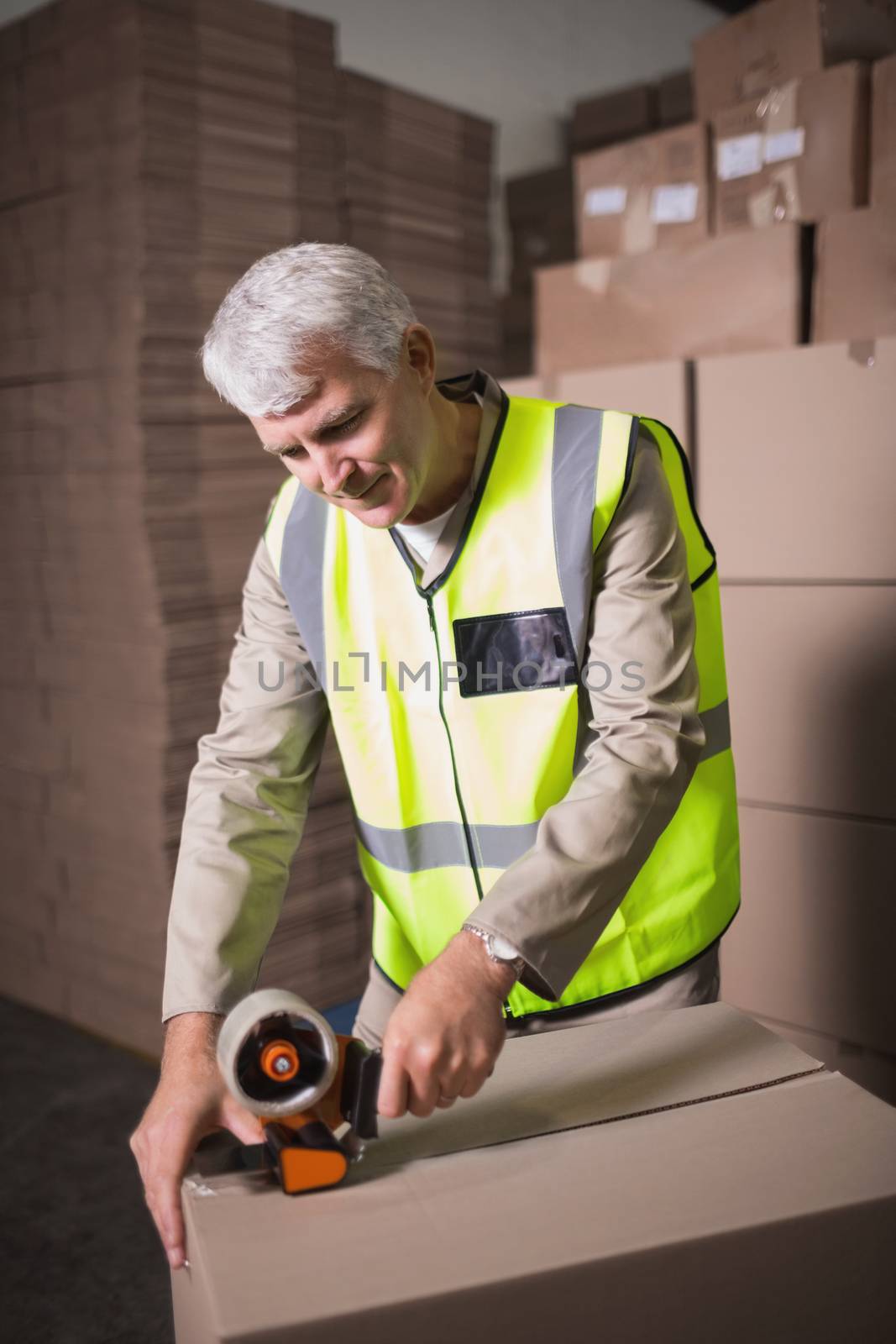 Worker in warehouse preparing goods for dispatch