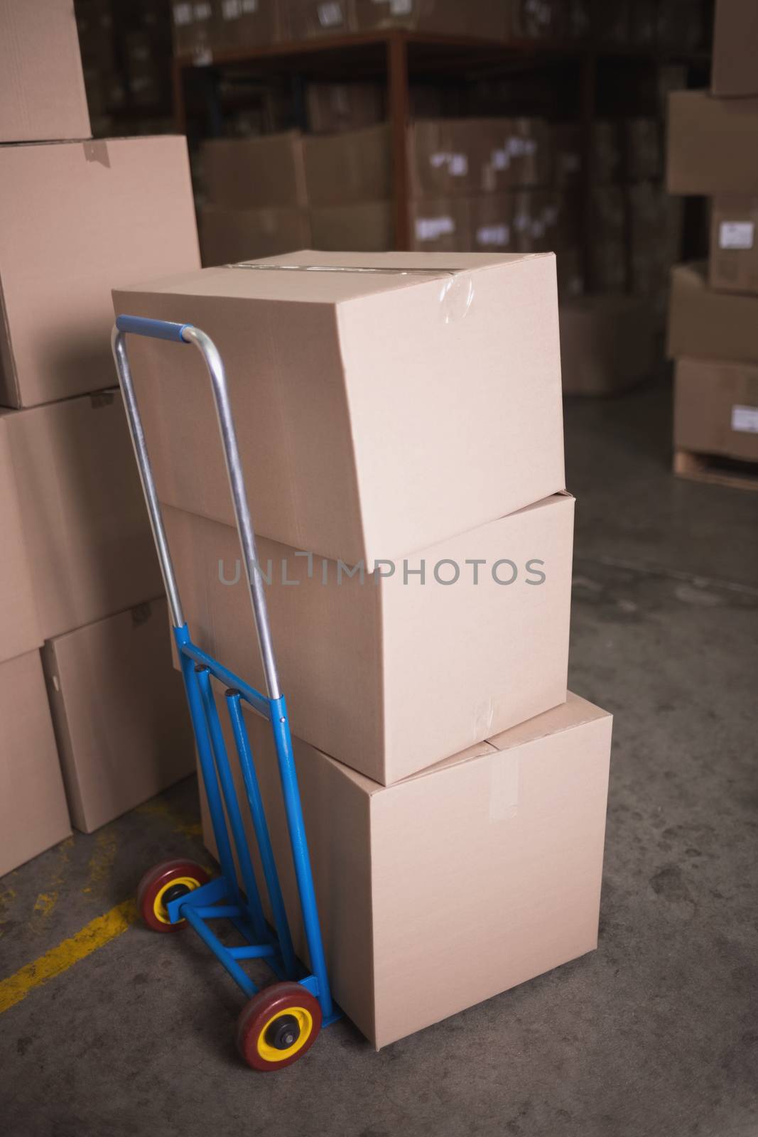 Boxes on trolley in warehouse by Wavebreakmedia
