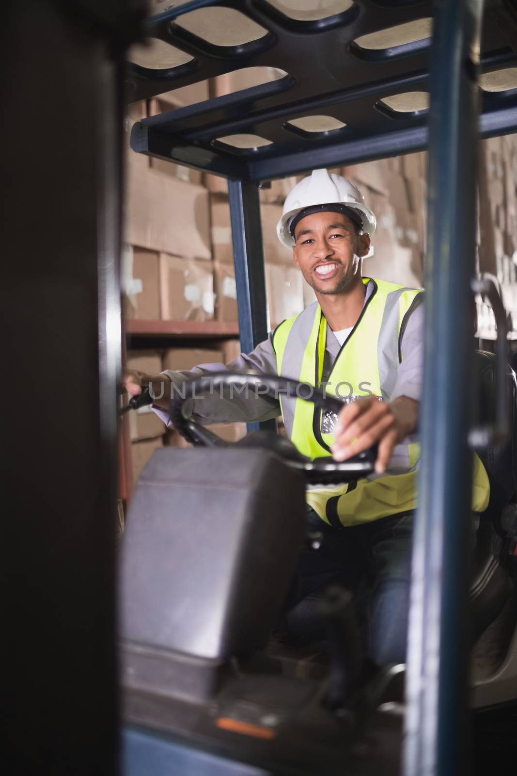 Portrait of driver operating forklift machine in warehouse