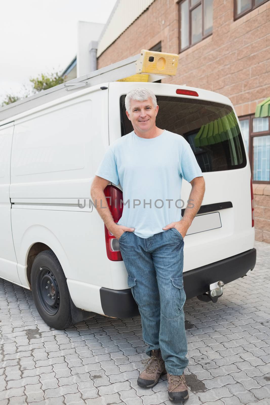 Full length portrait of smiling man standing against delivery van