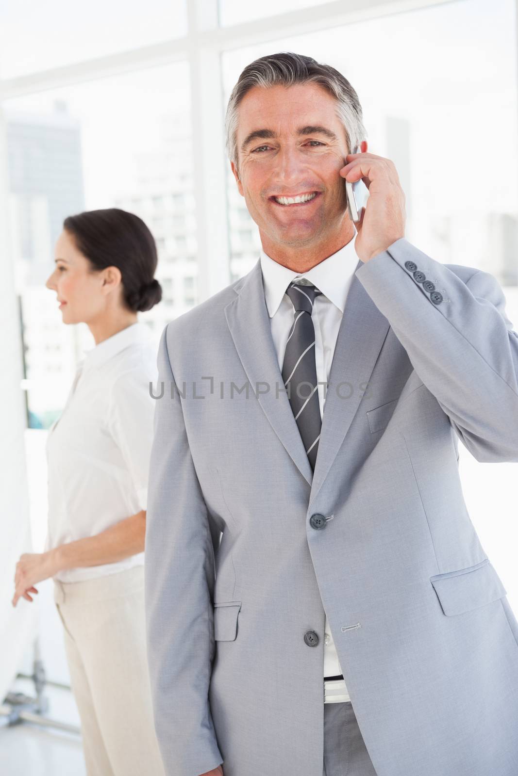 A smiling businessman using his mobile phone