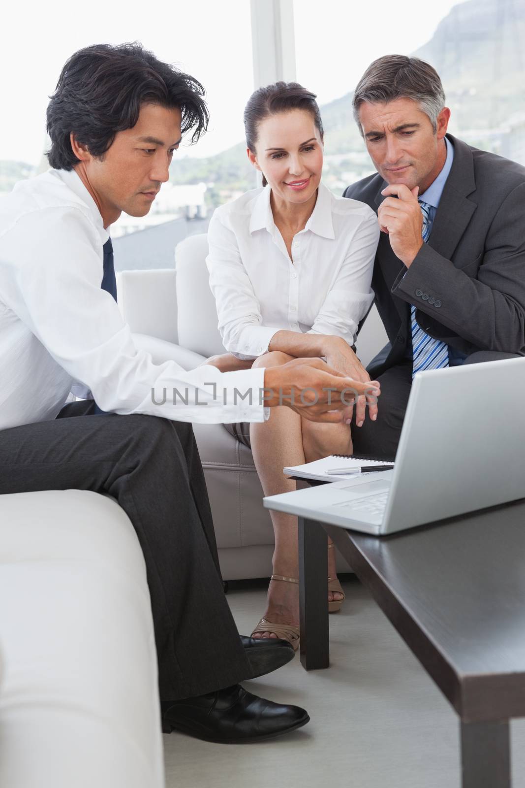 Business team looking at a laptop in an office