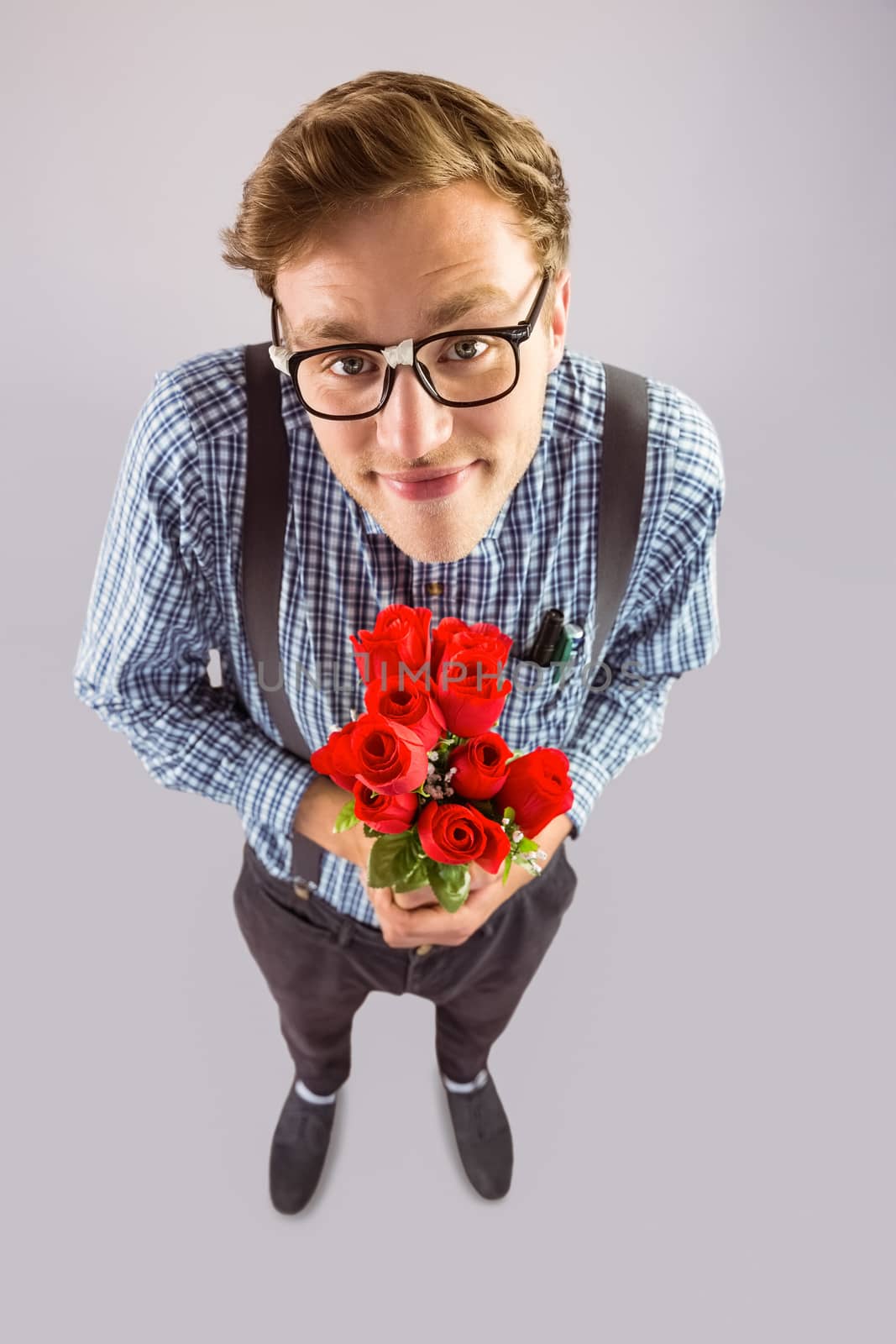 Geeky hipster holding a bunch of roses by Wavebreakmedia