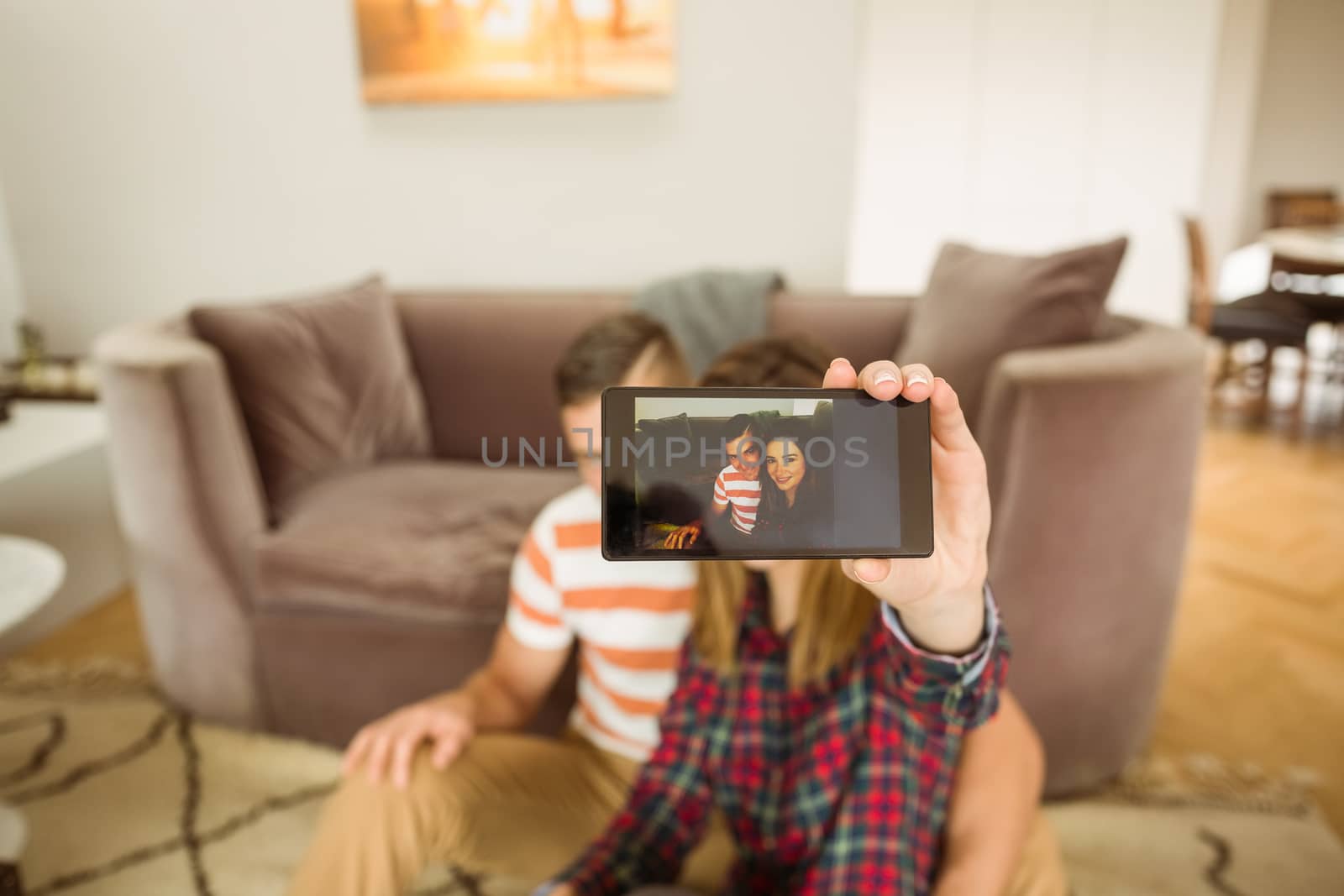 Cute couple taking a selfie at home in the living room