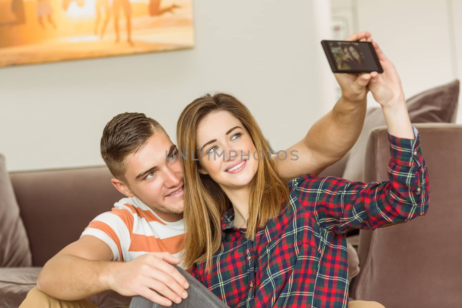 Cute couple taking a selfie at home in the living room
