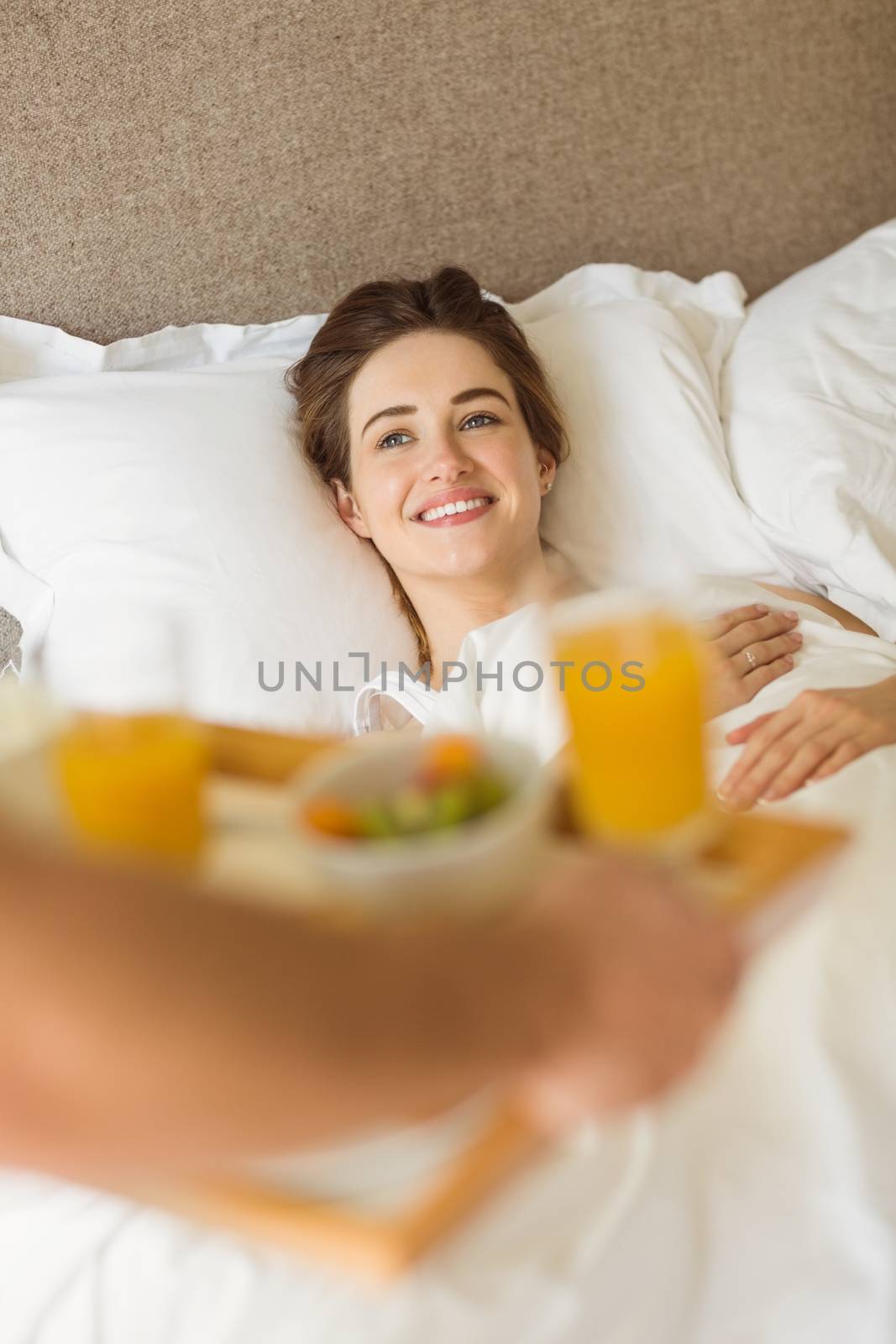 Cute couple having breakfast in bed at home in the bedroom