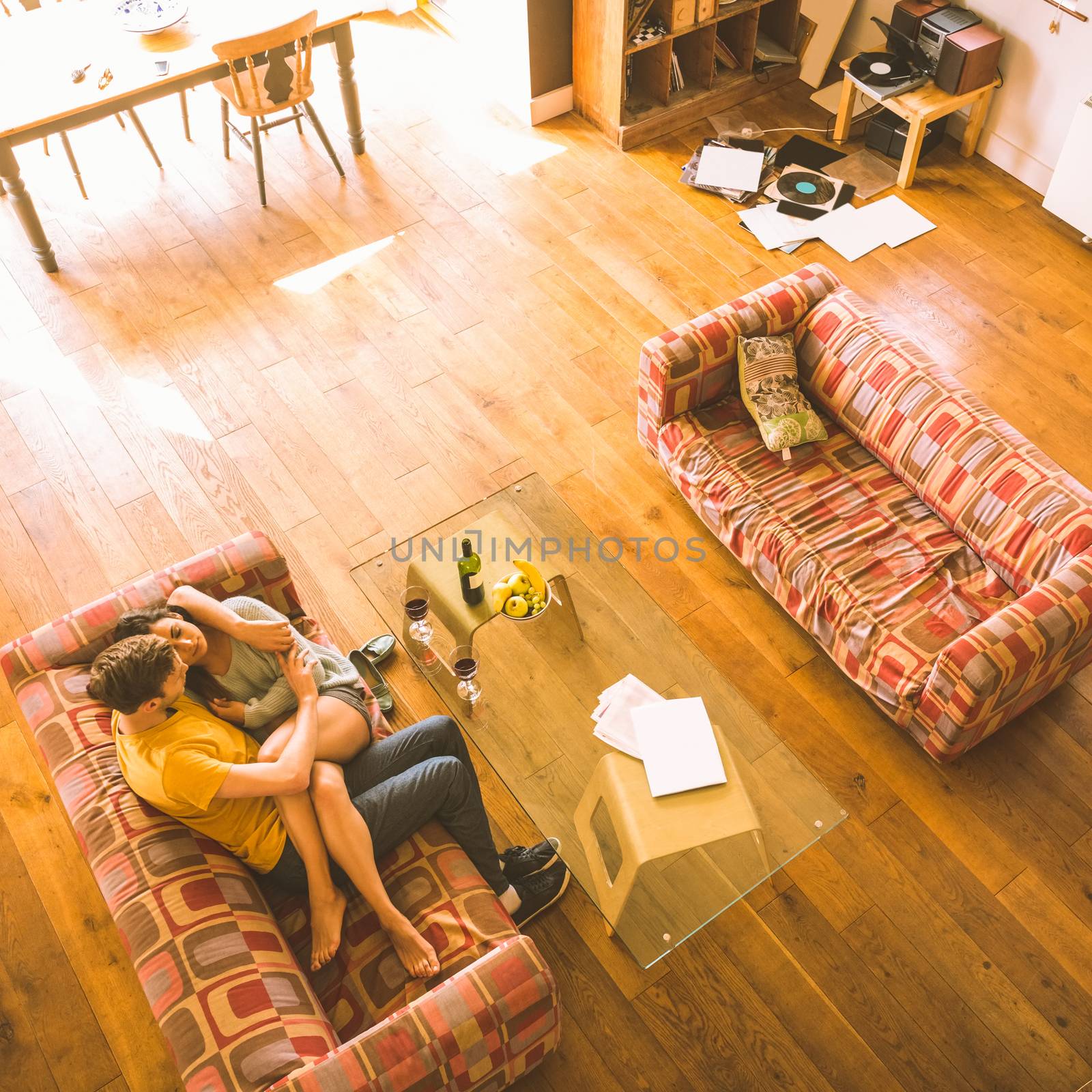 Young couple cuddling on the couch at home in the living room