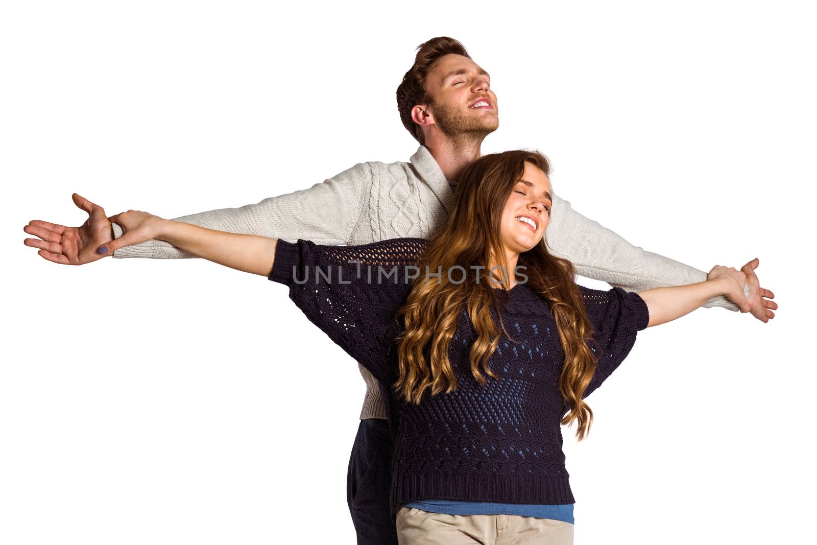 Romantic young couple with arms out standing over white background