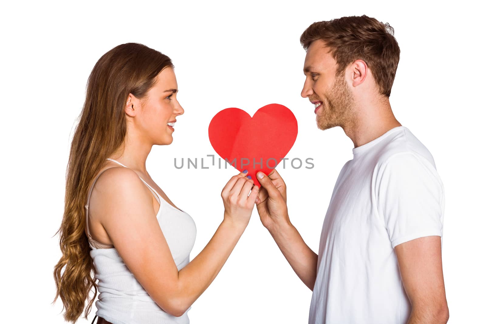 Side view of romantic young couple holding heart over white background