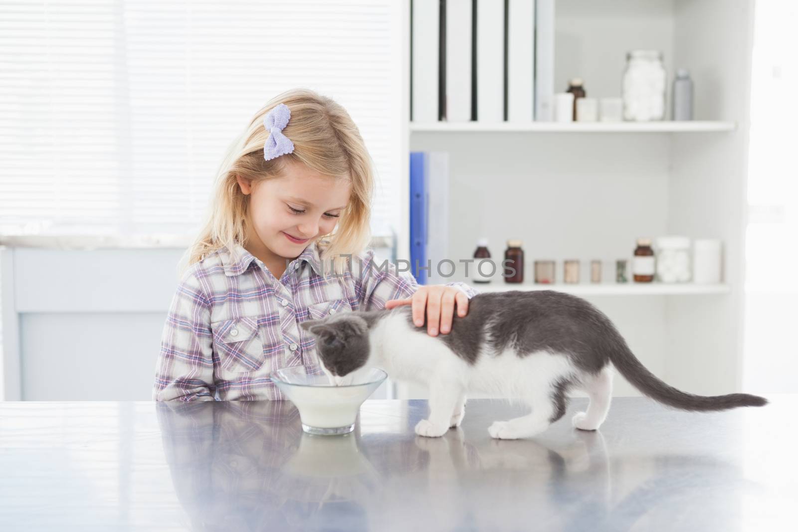 Happy owner petting her cat drinking milk by Wavebreakmedia