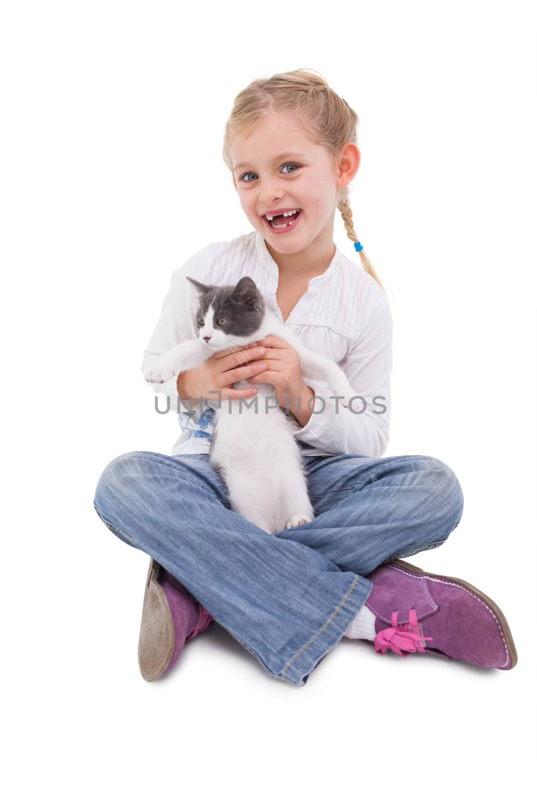 Happy little girl sitting with cat in her arms on white background